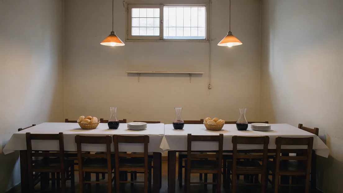 El salón con las mesas largas preparadas para una noche de pastas