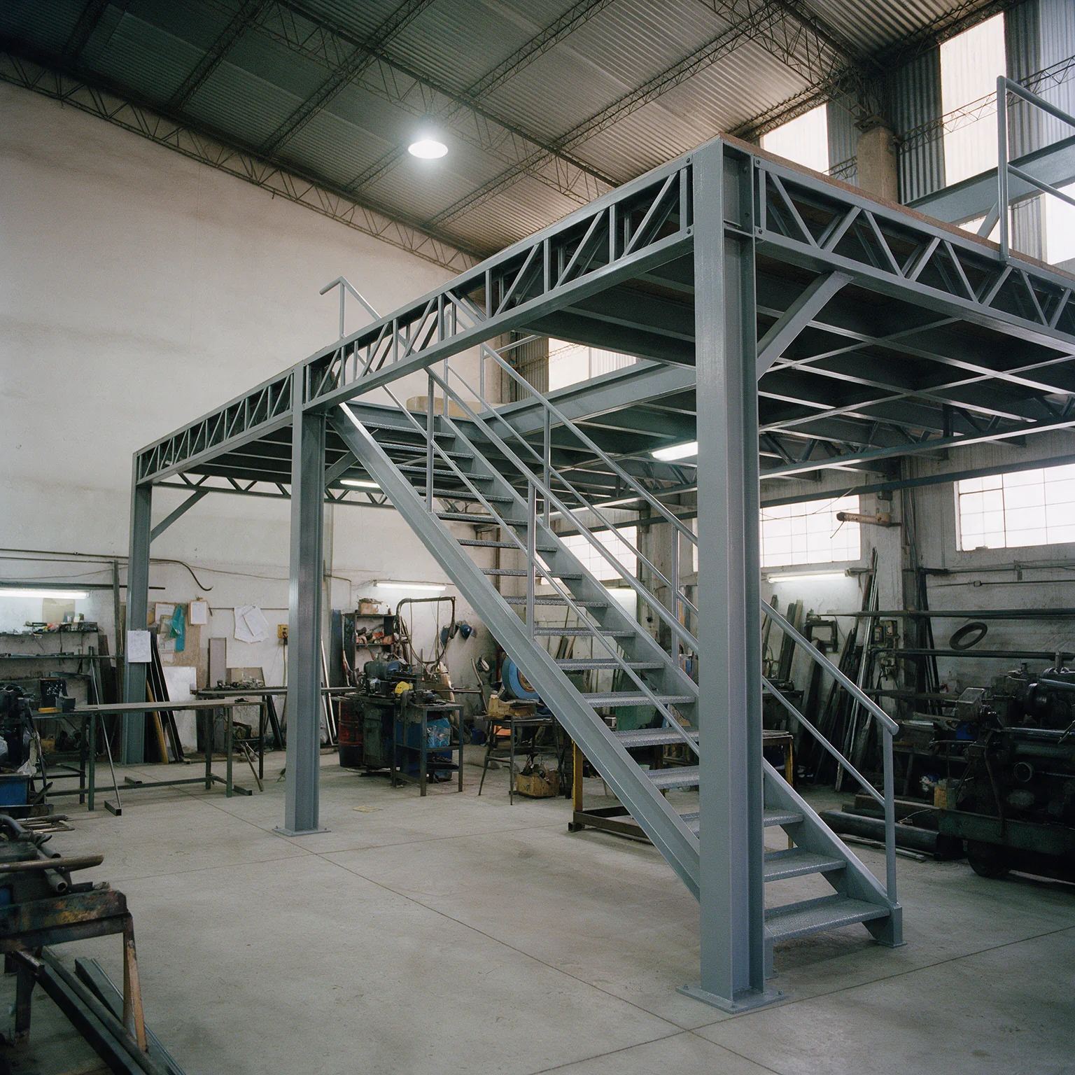 Estructura de entrepiso de acero con escalera, recién montada en una nave